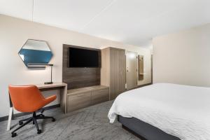 a bedroom with a bed and a desk and a television at Holiday Inn Express Greencastle by IHG in Greencastle
