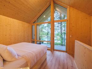 a bedroom with a bed and a large window at The Cabins at Terrace Beach in Ucluelet