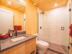 a bathroom with a toilet and a sink and a shower at The Cabins at Terrace Beach in Ucluelet