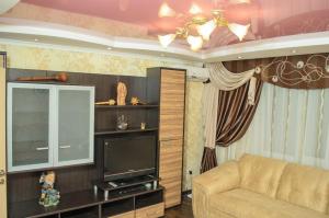 a living room with a couch and a television at Apartments on Proletarskaya in Sumy