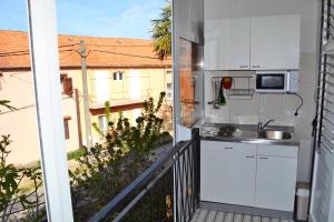 a balcony with a kitchen and a view of a building at Apartment Vlado in Sukošan