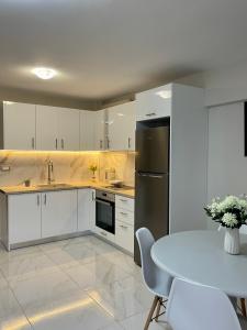 a kitchen with a table and a refrigerator at Arian Apartments in Argostoli
