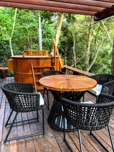 een houten tafel en stoelen op een houten terras bij Confraria Colonial Hotel Boutique in Mairinque