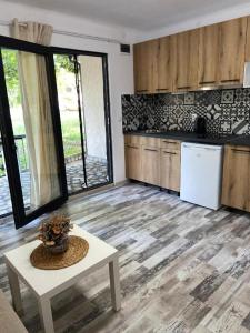 uma cozinha com uma mesa e um frigorífico branco em Villa Sea House 2 em Byala