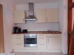 a kitchen with white cabinets and a stove top oven at Rustikal79 in Bleicherode