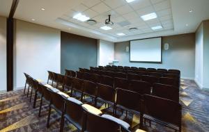 an empty lecture room with chairs and a screen at Garden Court Milpark in Johannesburg