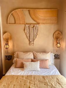 um quarto com uma cama com lençóis brancos e almofadas em LA TORRE Eco-Suite em Vejer de la Frontera