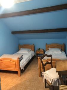 two beds in a room with blue walls at Petite maison in Planchez