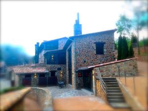 a large brick building with a staircase in front of it at Hotel Boutique Puig Francó - Adults Only in Camprodon