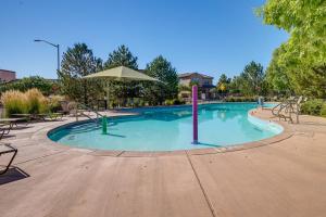 a large swimming pool with chairs and an umbrella at Pet-Friendly Albuquerque Vacation Escape! in Albuquerque
