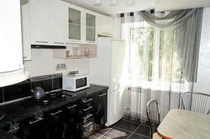 a kitchen with a black counter top and a window at Apartments on Proletarskaya in Sumy