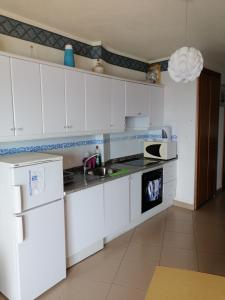 una cucina bianca con lavandino e forno a microonde di Apartamentos Vista Bahia a Los Cristianos