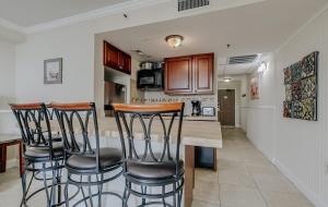 eine Küche mit drei Barhockern an einer Theke in der Unterkunft Breathtaking Ocean View 1 Bedroom Queen Suite! Meridian Plaza 707 - Perfect for 4 guests! in Myrtle Beach