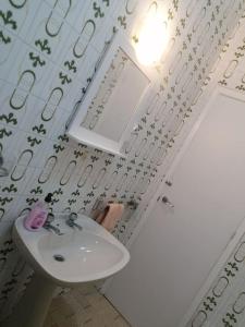 Baño blanco con lavabo y espejo en Piso céntrico o grove, en O Grove