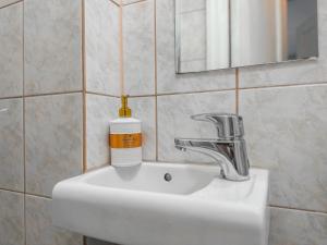 un lavandino in bagno con una bottiglia di sapone di Residential Hotels Kallio a Helsinki