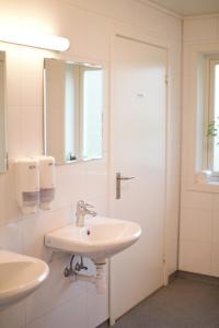 uma casa de banho branca com 2 lavatórios e um espelho em Sognhostel em Sørbø