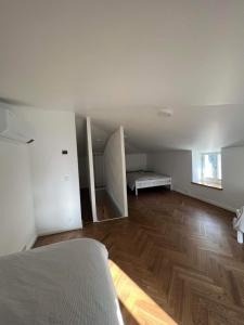 een lege kamer met een bed en een houten vloer bij Mere in Pärnu