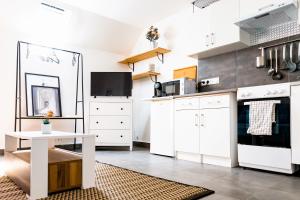 a kitchen with white cabinets and a table at LMK in Serris