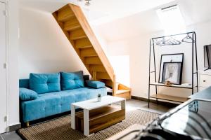 a living room with a blue couch and stairs at LMK in Serris