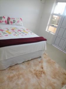 ein Schlafzimmer mit einem Bett mit einem Teppich neben einem Fenster in der Unterkunft Glenwood in Durban