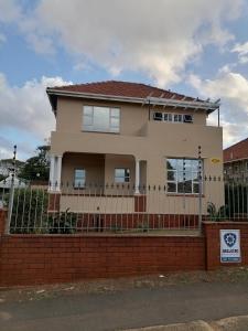 une maison avec une clôture devant elle dans l'établissement Glenwood, à Durban