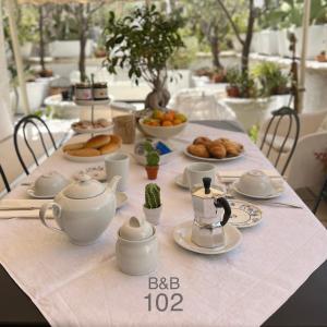 una mesa con teteras y platos de comida. en B&B 102, en Taranto