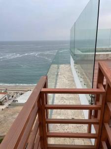 uma varanda com vista para a praia e para o oceano em Loft acogedor con área de parrilla y piscina em Punta Hermosa