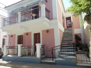 una casa rosa con escaleras delante en Maria's Studios, en Skala Kallonis