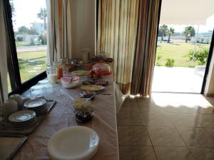 a table with plates and food on it with a window at Anthia Apartments in Marmari