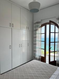 a bedroom with white cabinets and a view of the ocean at Blue Wave Apartment in Kiáton +5 photos