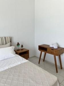 Schlafzimmer mit einem Bett und einem Holztisch in der Unterkunft Blue Wave Apartment in Kiato