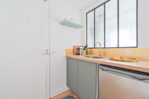 uma cozinha com um lavatório e um chuveiro em Studio Parisien - Quai Valmy em Paris