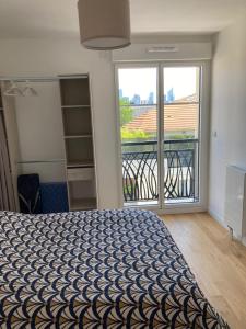 a bedroom with a bed and a large window at Very nice and quiet 38 m in Suresnes with parking in Suresnes