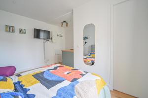 um quarto com uma cama e um espelho em Studio Parisien - Quai Valmy em Paris