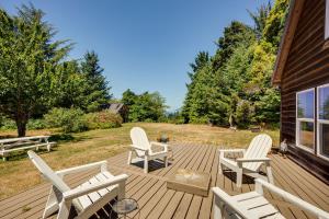 a wooden deck with chairs and a fire place at Gold Beach Vacation Rental Close to Beaches! in Ophir
