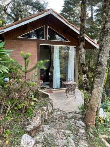 a small house with a patio and a table at Zatara's Lodge - Monte Verde MG in Camanducaia