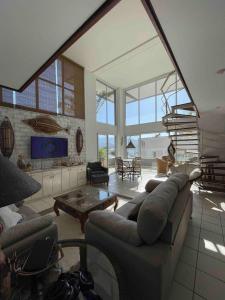 a living room with a couch and a table at DUPLEX MONTECARLO in Ubatuba