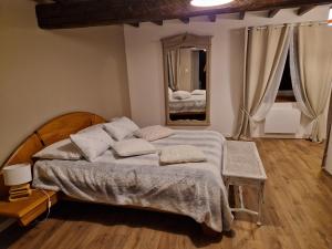 - une chambre avec un grand lit et un miroir dans l'établissement Le Grand Cerf - 4 Couchages, à Nalzen