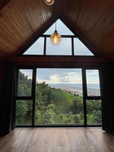 a room with a large window with a view of the ocean at Mutlu apart ve bungalovs in Pazar