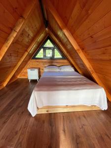 a bed in a wooden room with a window at Mutlu apart ve bungalovs in Pazar