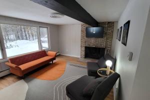 a living room with a couch and a fireplace at Stratton Tree House in Strattonwald