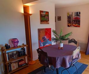 uma sala de jantar com uma mesa com uma planta em Les Villas de Beaulieu em Caen