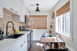 a kitchen with a sink and a wooden table at Minimal - 30 nights minimum in Vancouver