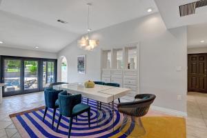a dining room with a white table and blue chairs at Our Poolside Desert Nirvana in Palm Springs +34 photos