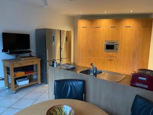 a kitchen with wooden cabinets and a sink and a table at Wilgentuin in Bekkevoort