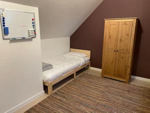 a small bedroom with a bed and a wooden cabinet at Wilgentuin in Bekkevoort