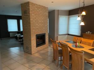 a dining room with a table and a brick fireplace at Wilgentuin in Bekkevoort