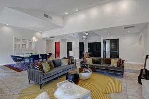 a living room with couches and a dining room at Our Poolside Desert Nirvana in Palm Springs