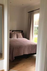 a bedroom with a bed and a window at Vakantiewoning Mystiek in Zutendaal