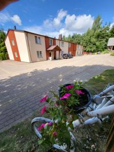 een fiets geparkeerd op het gras met een plant bij Šilainė Recreation & Leisure in Oszkinie